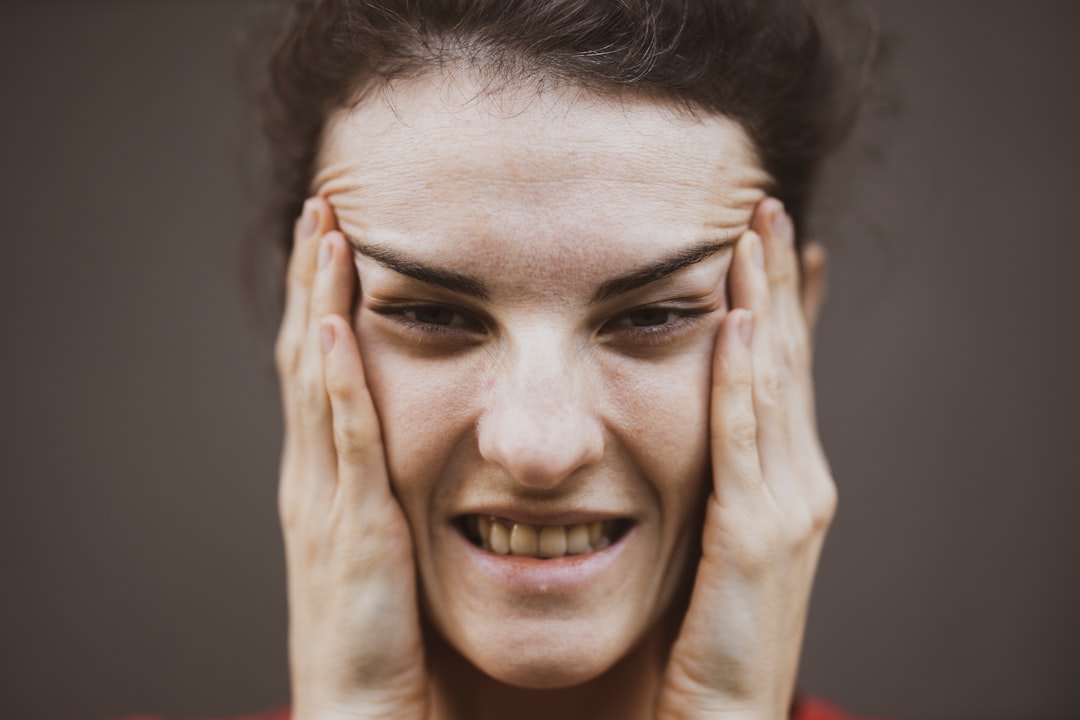 Woman holding her jaw in pain after waking with sore muscles from teeth grinding